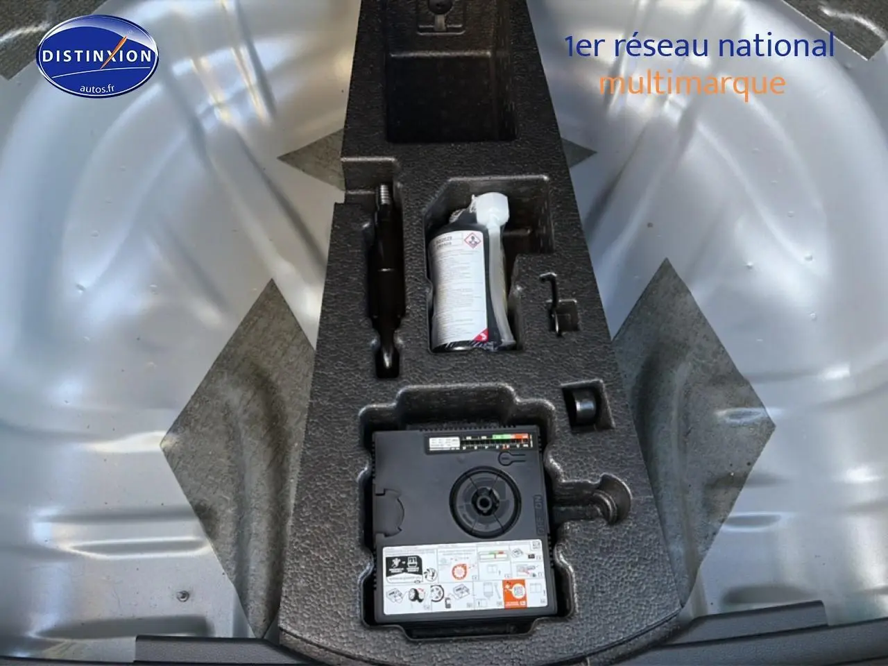 Détail du coffre gris d’un Skoda Karoq 1.5 TSI 2025 montrant le kit de réparation pneus intégré.