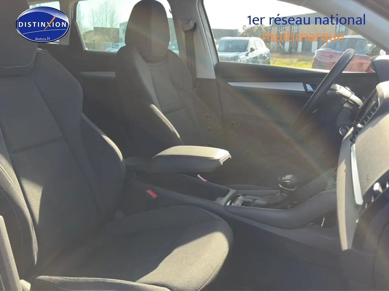 Intérieur avant du Skoda Karoq gris 2025, vue côté droit sur sièges et console centrale avec accoudoir.