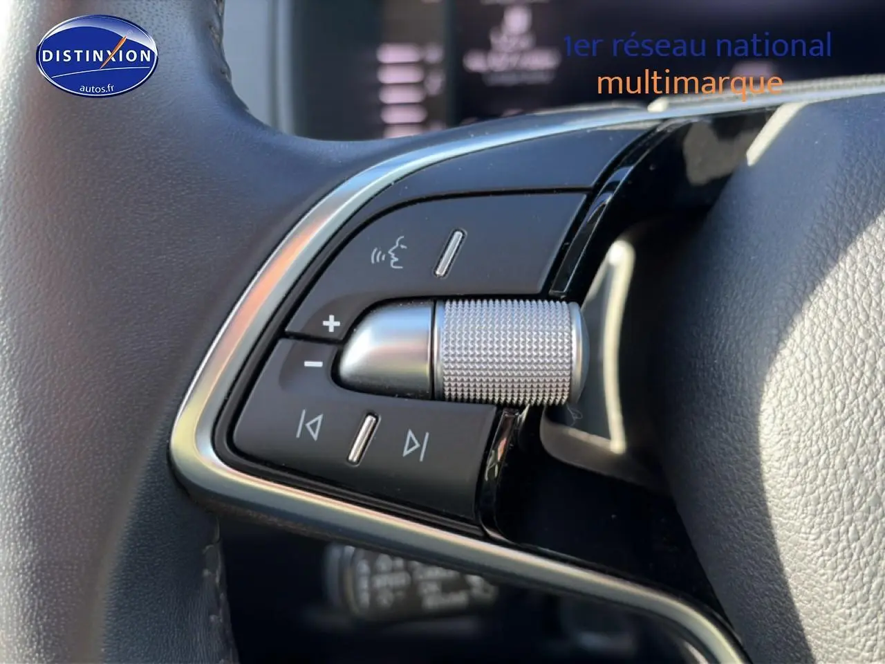 Gros plan sur les commandes audio au volant cuir du Skoda Karoq gris, version 1.5 TSI 150 DSG7, 2025.