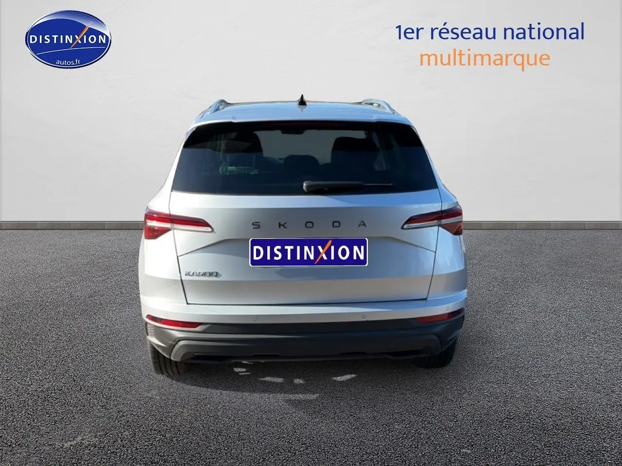 Vue arrière d'un Skoda Karoq gris 2025 avec feux LED et barres de toit visibles sur fond neutre.