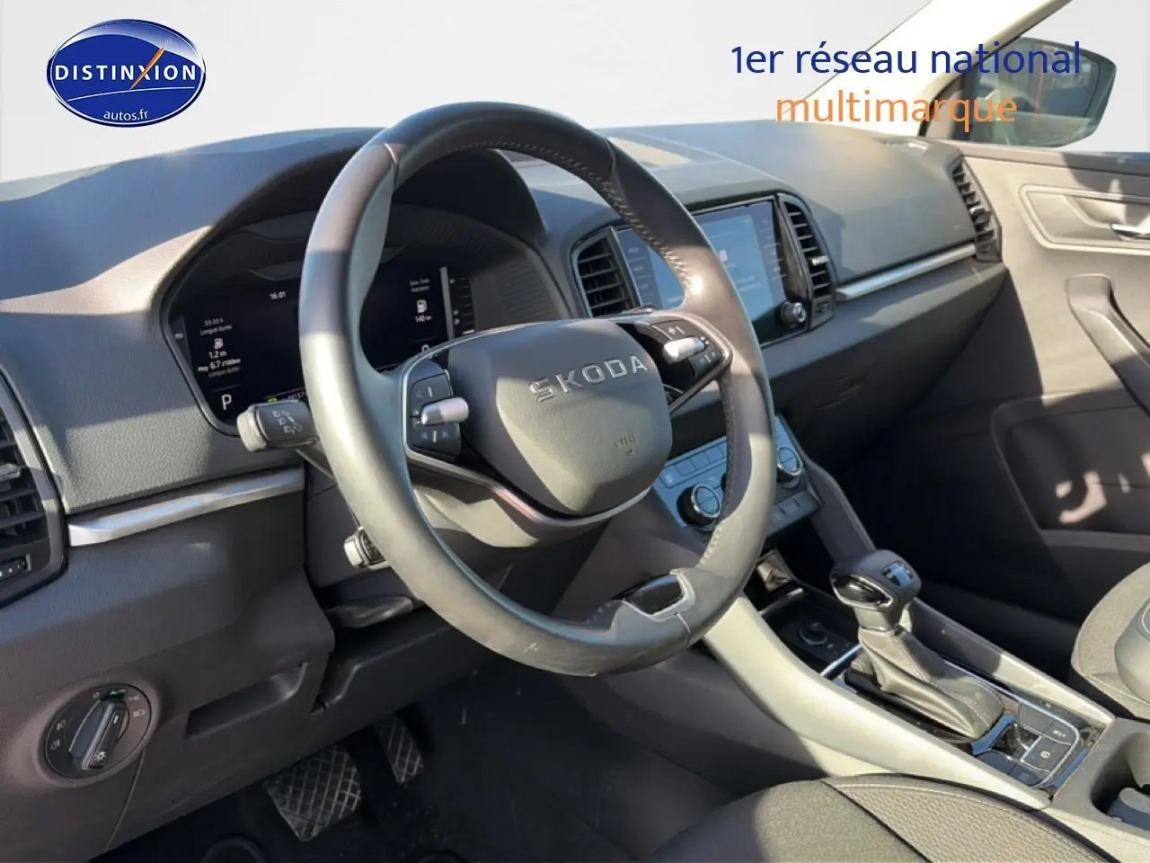 Vue intérieure côté conducteur du Skoda Karoq gris 2025, mettant en valeur le volant multifonction et la console centrale.