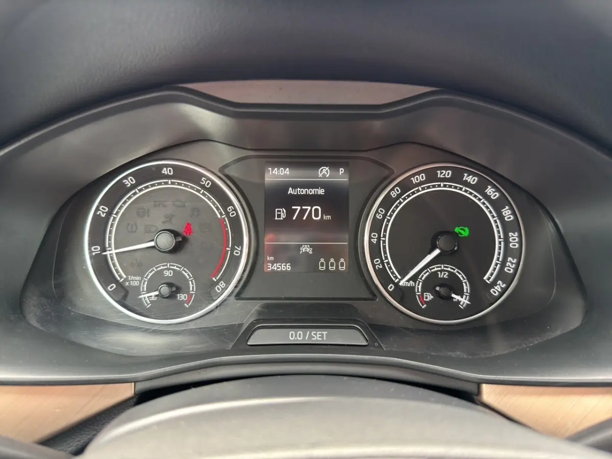 Vue rapprochée du combiné d'instruments du Skoda Kamiq 2023, affichant l'autonomie et compteurs analogiques.