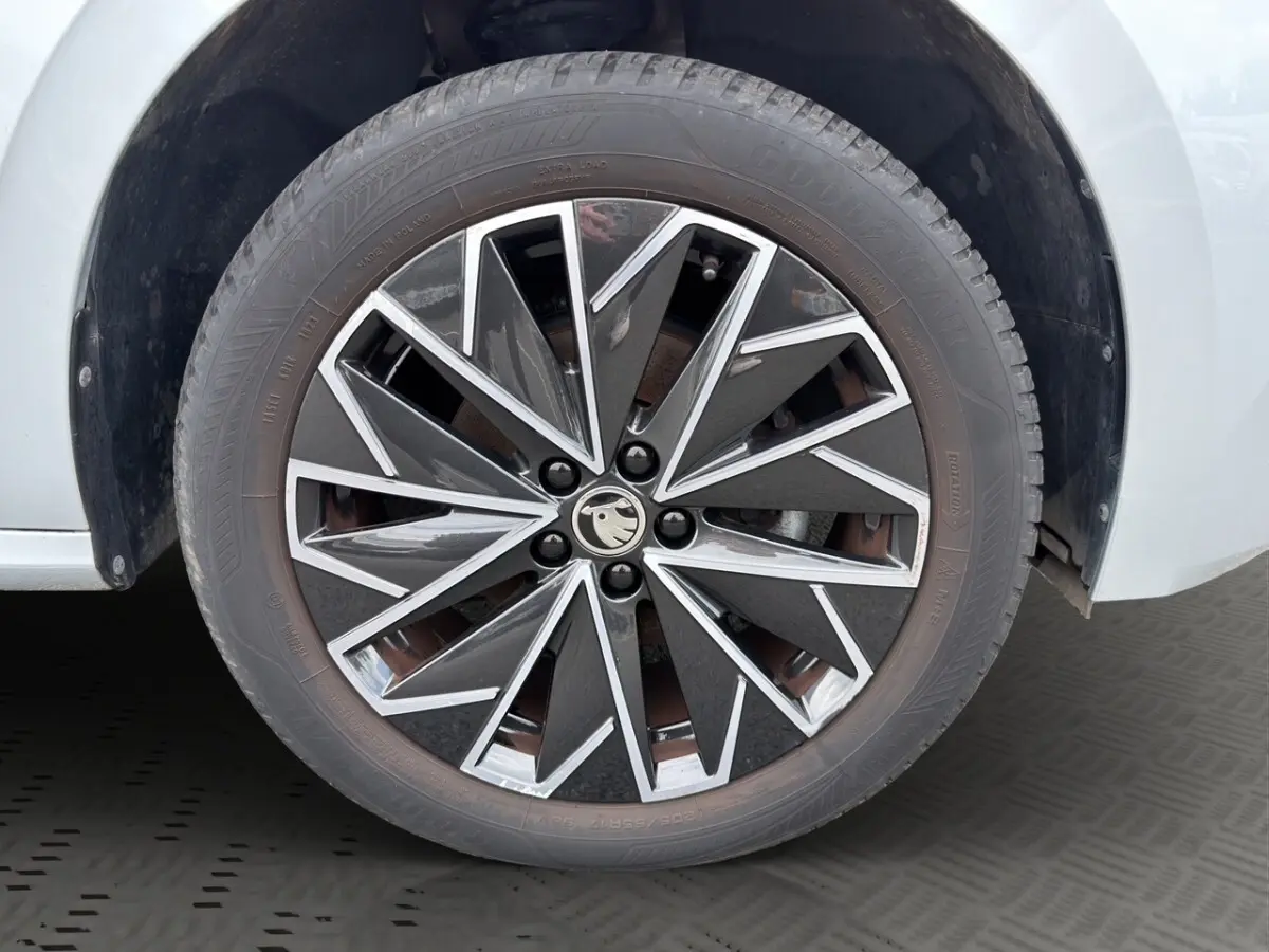 Gros plan sur la jante bi-ton noire et argentée d'une Skoda Kamiq gris clair, roue avant droite.