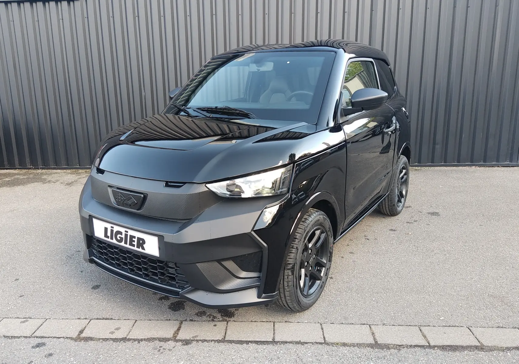 LIGIER JS60 Nouvelle Revo D+ Select noir intense, vue 3/4 avant avec jantes alu noires et calandre carbone.