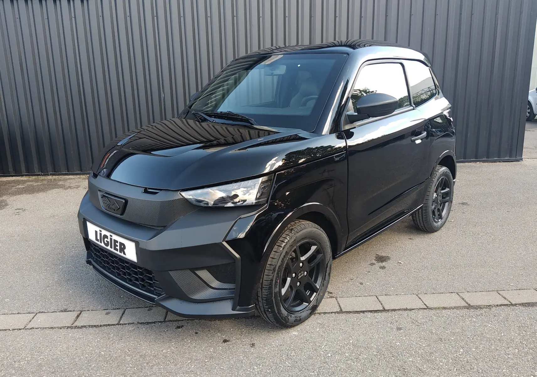LIGIER JS60 Nouvelle Revo D+ Select noir intense, vue 3/4 avant avec jantes alu noires et calandre marquée.