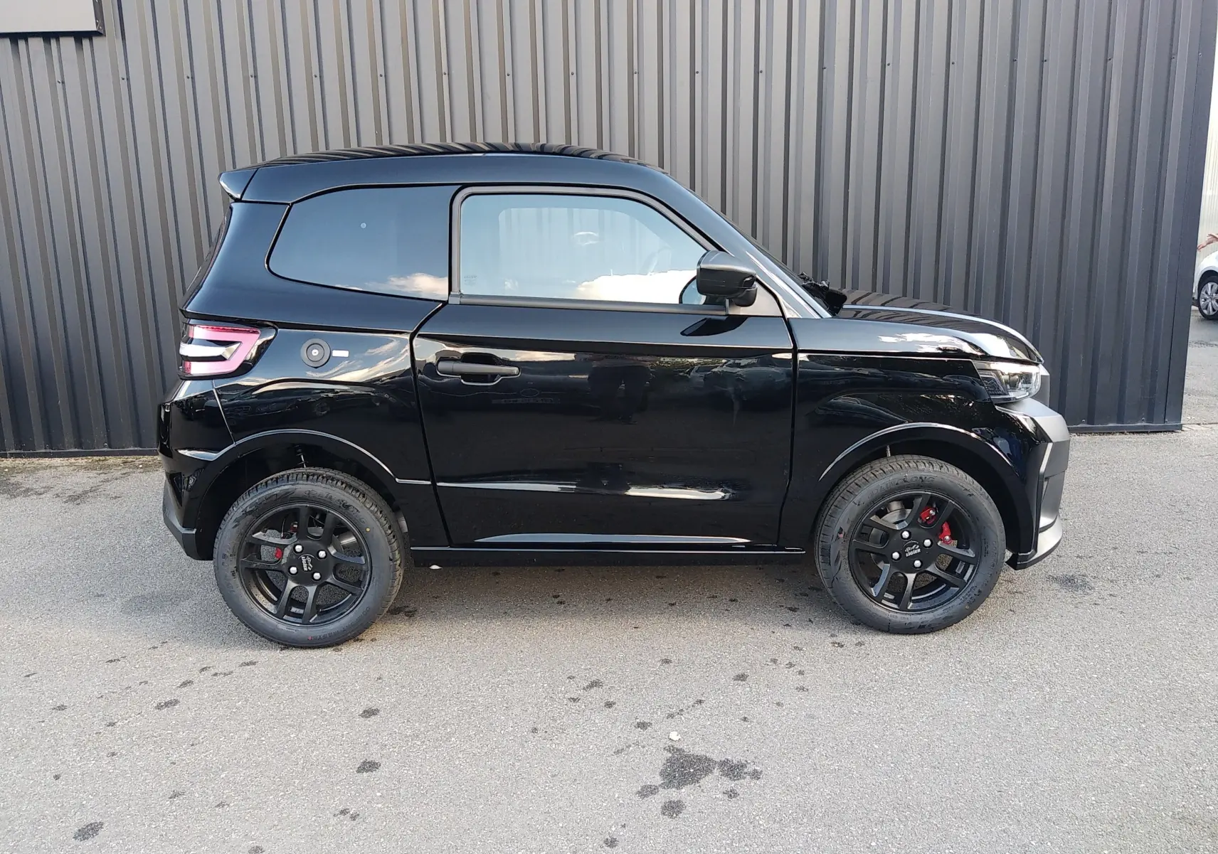 Profil droit de la LIGIER JS60 Nouvelle Revo D+ Select noire, avec jantes alu noires et becquet arrière simple.