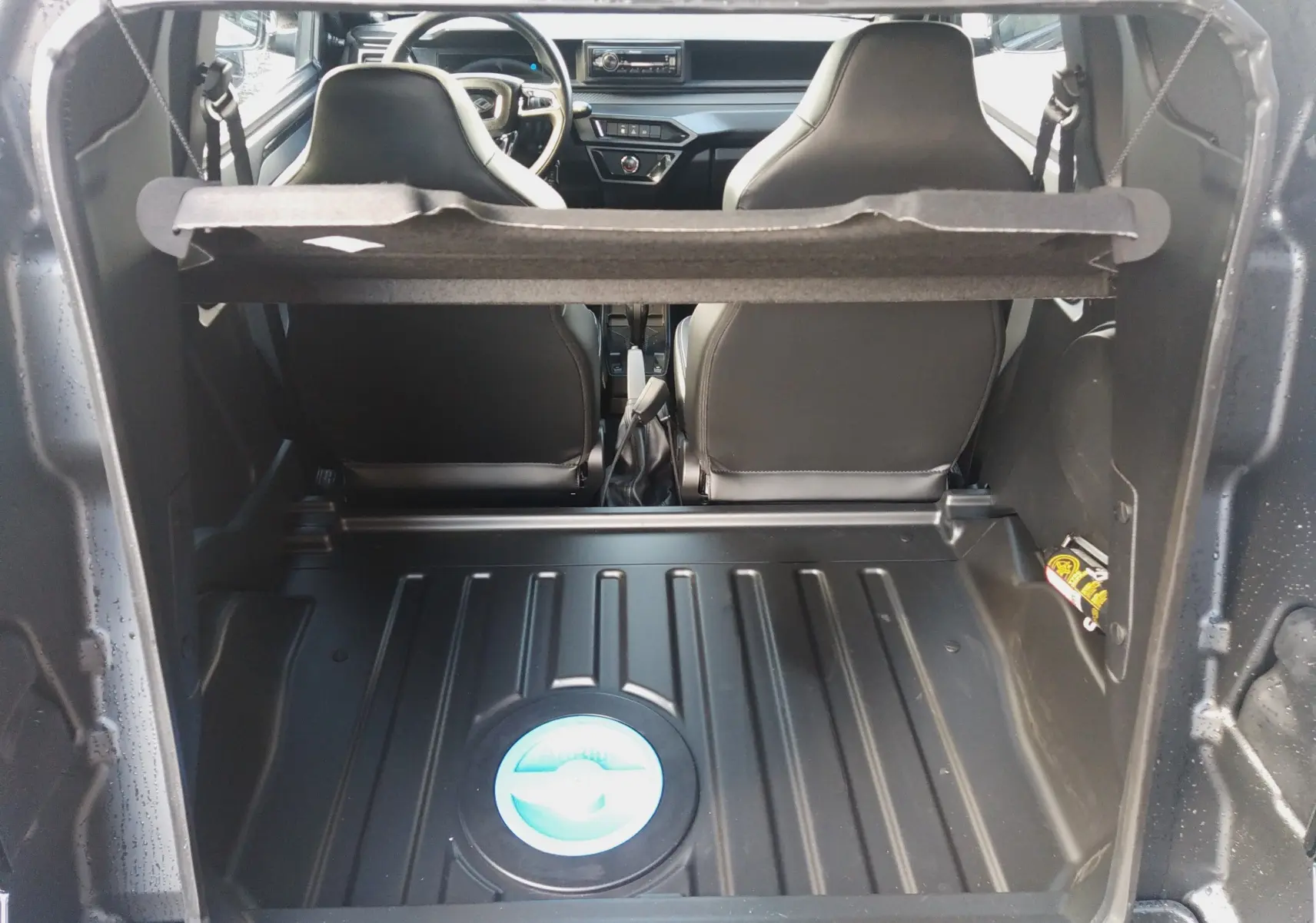 Vue arrière du coffre ouvert de la LIGIER JS60 Nouvelle Revo D+ Select noir intense, montrant les sièges avant et planche de bord.