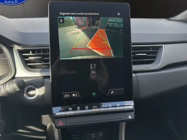 Vue intérieure du tableau de bord du Renault Captur 2025, écran tactile affichant la caméra de recul avec lignes de guidage colorées.