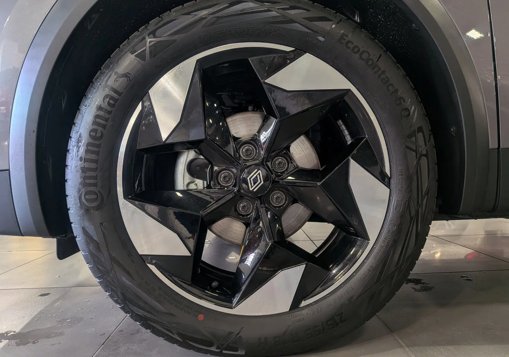 Gros plan sur la jante noire et argentée du côté gauche d'un Renault Captur 2025 gris Cassiopé toit noir.