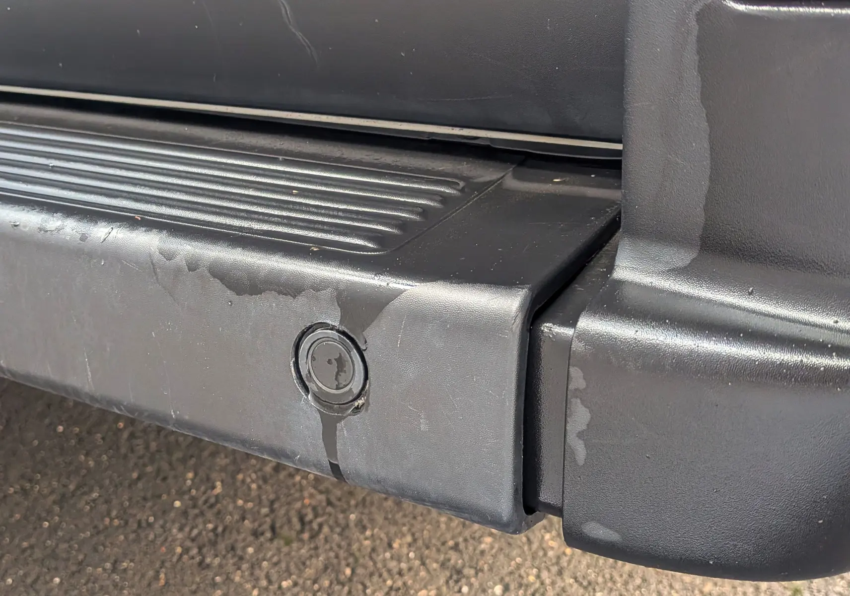 Gros plan sur le pare-chocs arrière noir du FIAT Ducato Fourgon blanc, montrant un capteur de stationnement intégré.