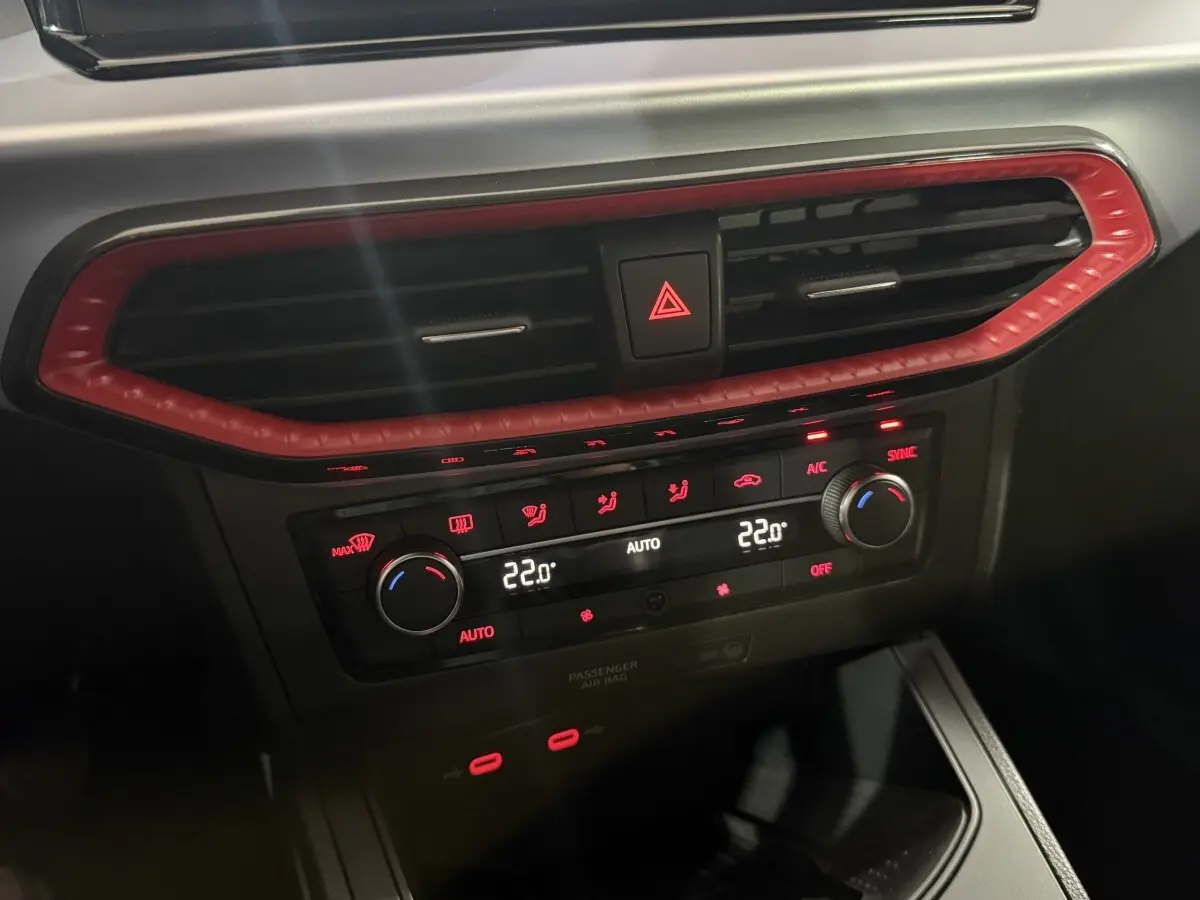 Détail du tableau de bord de la SEAT Ibiza 1.0 TSI 110 FR 2024, avec ventilation et commandes climatisation rouges.