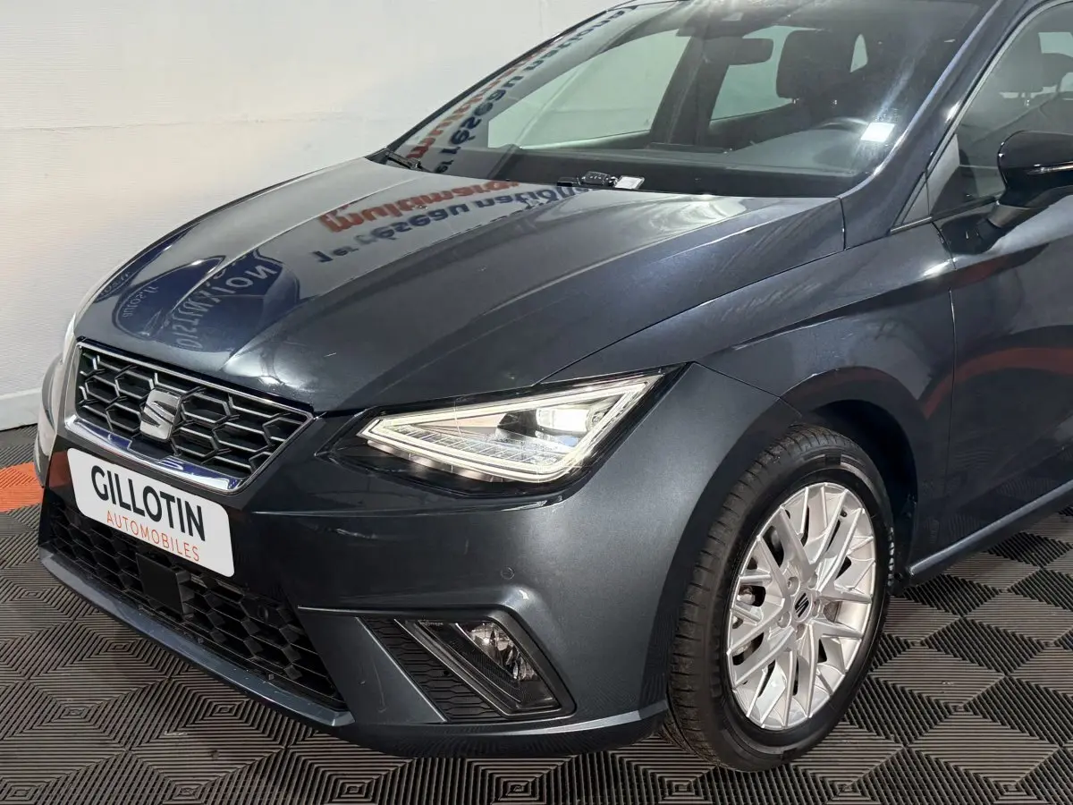 SEAT Ibiza 1.0 TSI 110 FR gris foncé vue 3/4 avant droit avec phares LED et jantes alliage visibles.