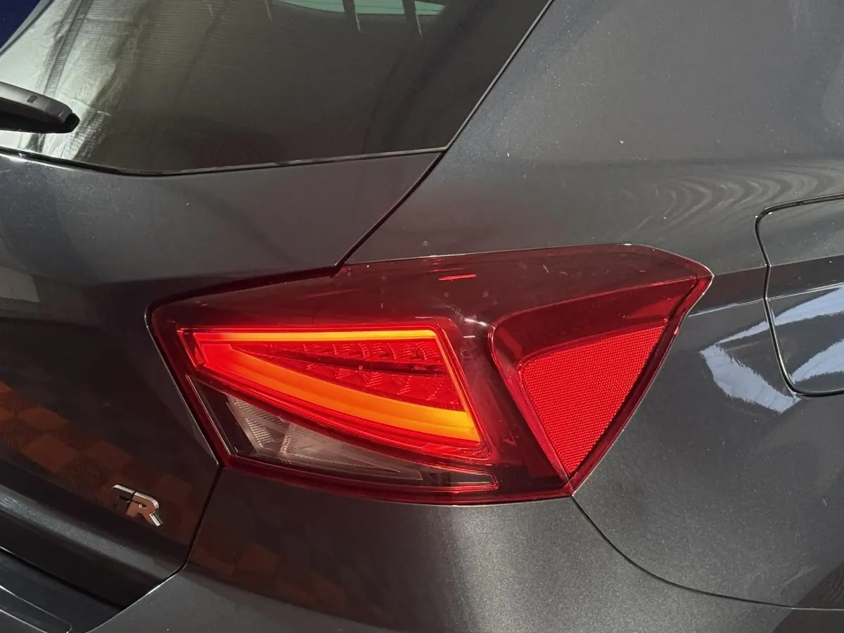 Feu arrière droit allumé sur SEAT Ibiza 1.0 TSI 110 FR gris foncé, avec logo FR visible sur le coffre.