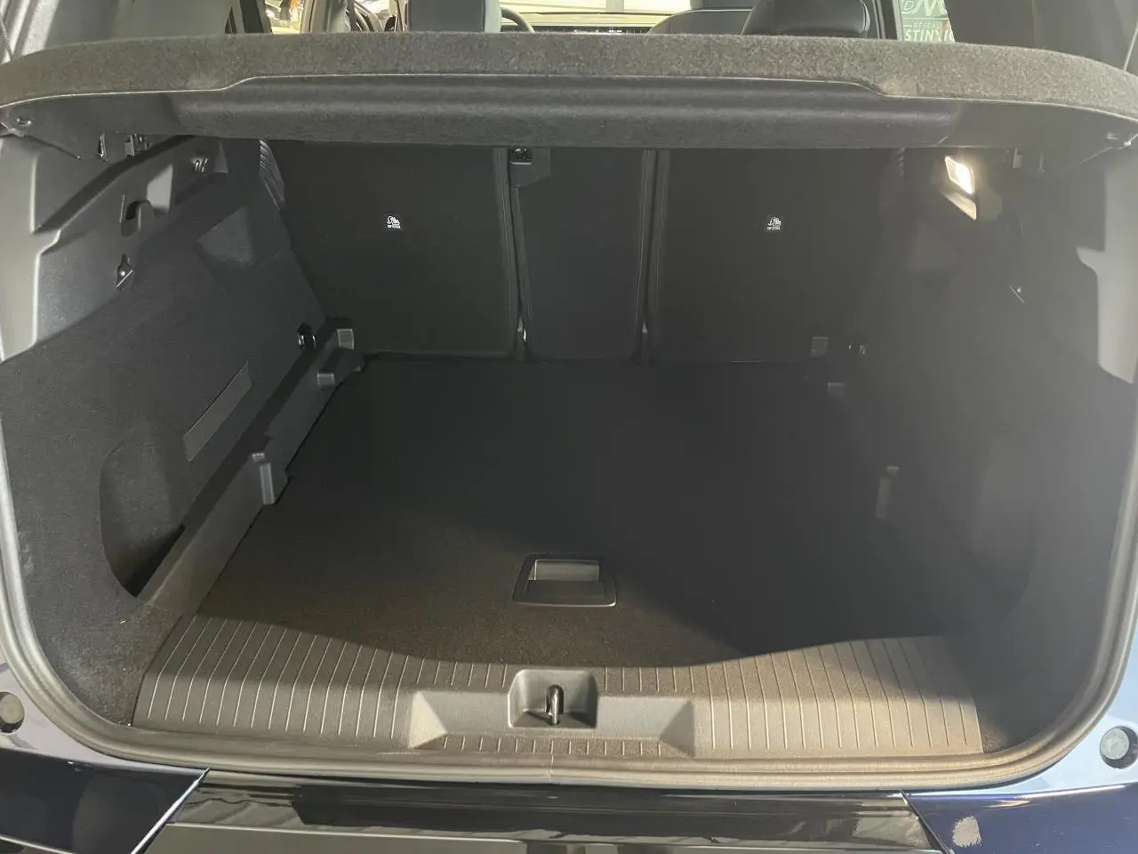 Coffre ouvert vu de l'arrière d'un Citroën C5 Aircross bleu Azul, montrant l'espace de chargement vide.