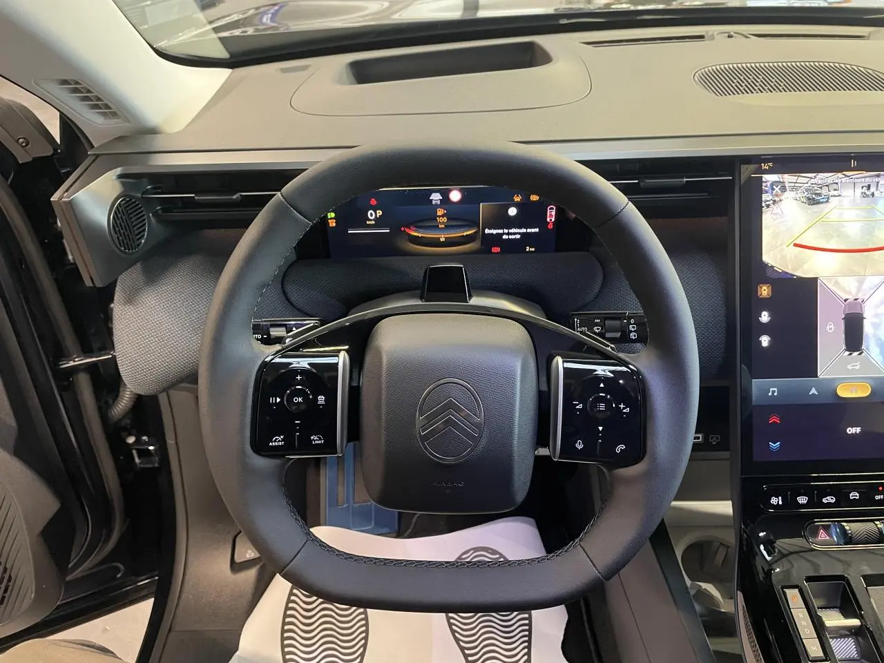 Vue intérieure centrée sur le volant noir multifonctions et les écrans numériques du tableau de bord du Citroën C5 Aircross.