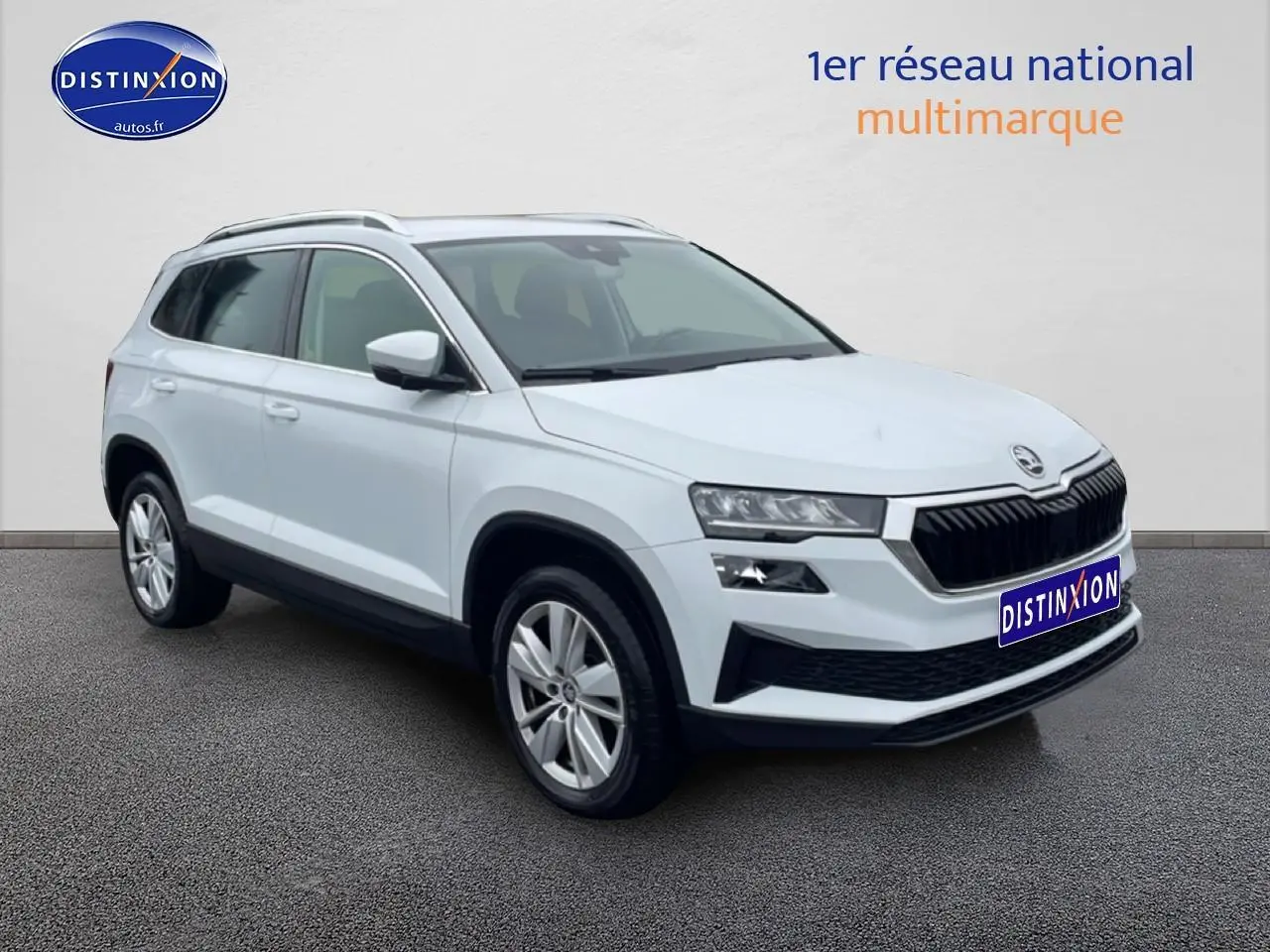 SKODA KAROQ blanc glacial en 3/4 avant droit avec jantes alu et calandre noire distinctive.