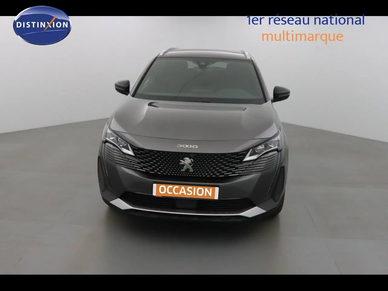 Vue frontale d'un Peugeot 3008 gris platinium métal avec calandre noire et logo lion central bien visible.