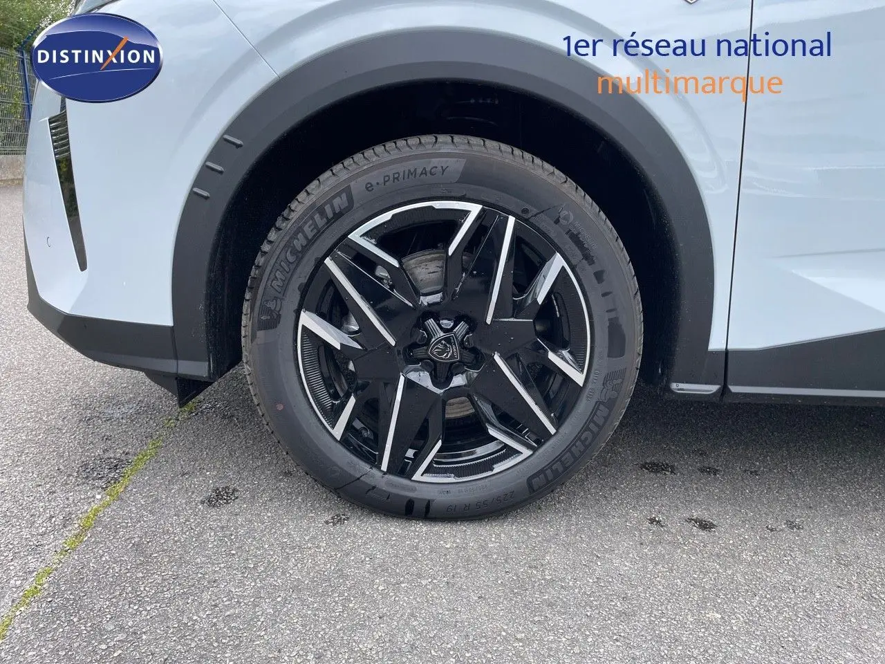 Gros plan sur la roue avant gauche du Peugeot 5008 blanc Okenite avec jante noire et argentée en 2025.