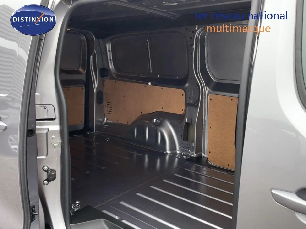 Vue intérieure du coffre arrière ouvert du Citroën Jumpy gris Artense métal, montrant l’espace de chargement vide et les panneaux latéraux.