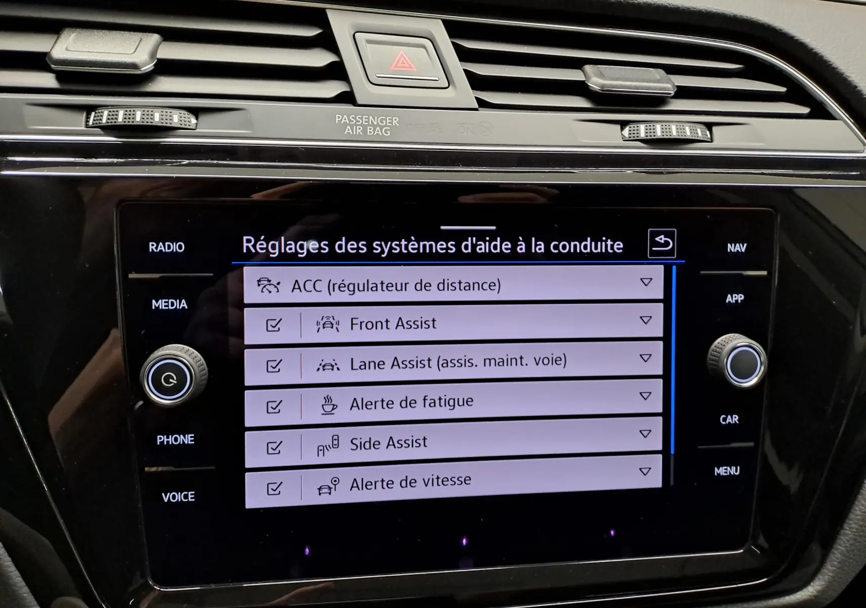 Vue de profil côté gauche d'un Volkswagen Touran gris argent avec jantes alliage et toit ouvrant panoramique.