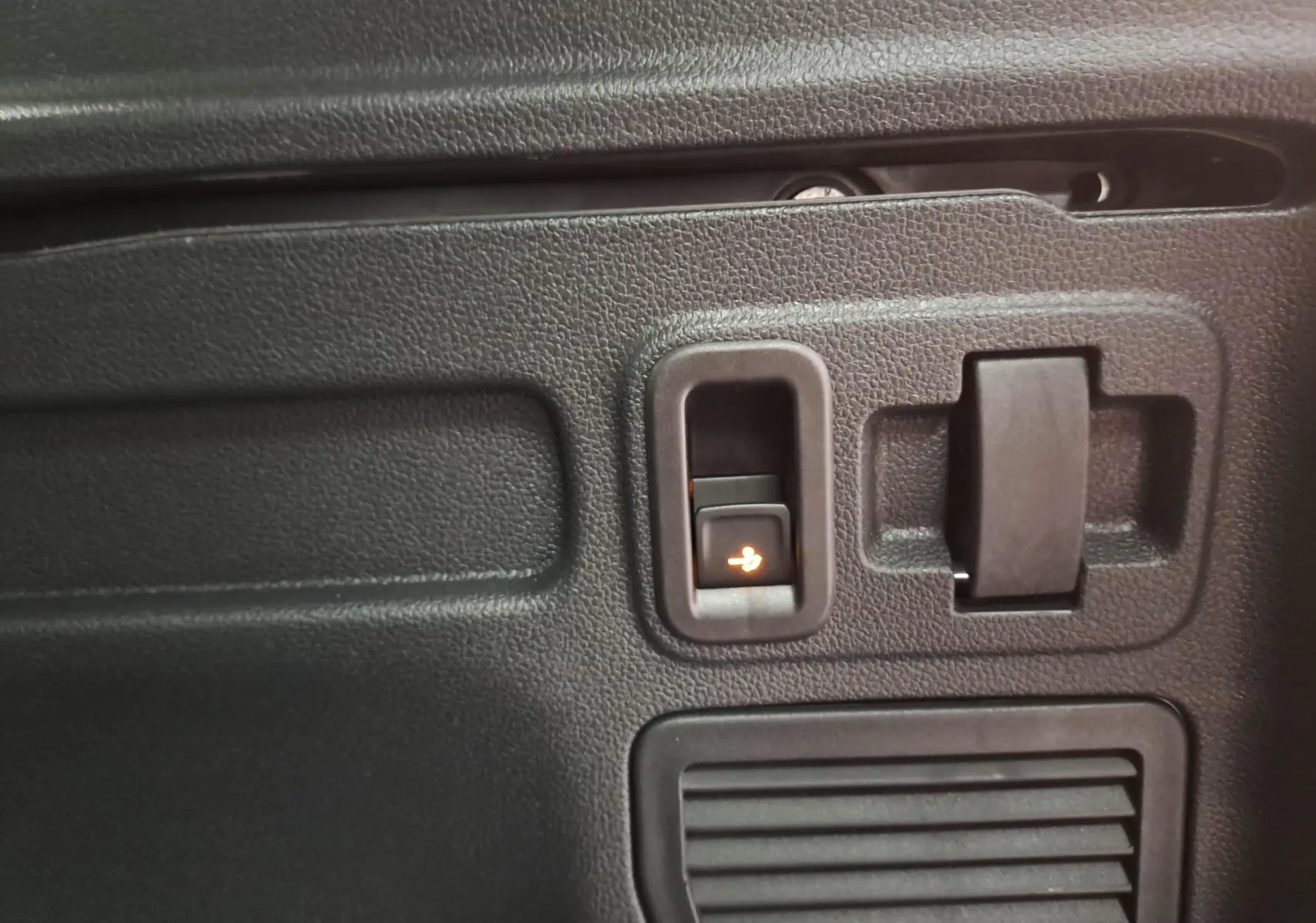 Détail du panneau intérieur noir avec commande électrique d'ouverture du hayon sur Volkswagen Touran gris argent 2025.