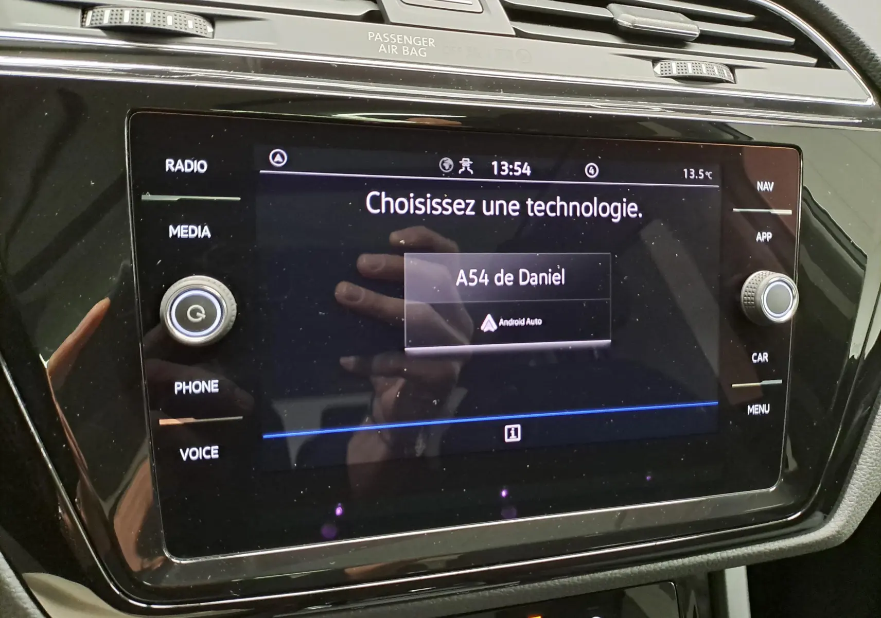 Écran tactile central du Volkswagen Touran 2025 affichant le menu Android Auto, entouré de commandes noires brillantes.