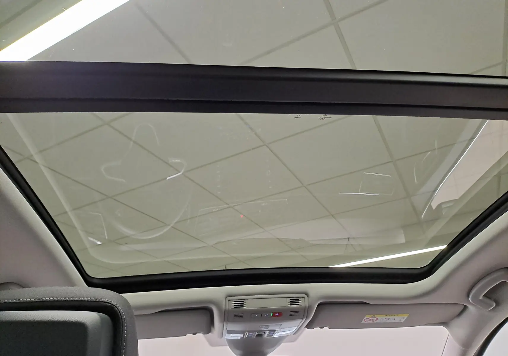 Vue intérieure du toit ouvrant panoramique en verre du Volkswagen Touran gris argent, mettant en valeur l'espace lumineux.