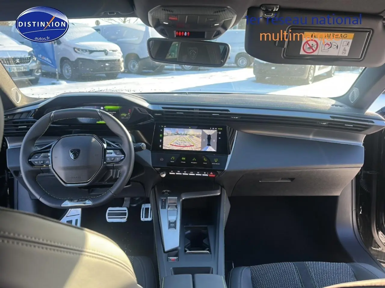 Vue intérieure avant de la Peugeot 408 Hybrid noire 2025, tableau de bord moderne avec écran tactile et volant compact.