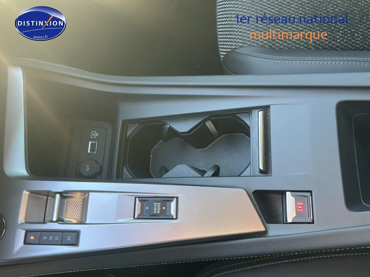 Vue plongeante sur la console centrale noire du Peugeot 408 Hybrid 145 GT avec commandes de boîte auto et porte-gobelets.