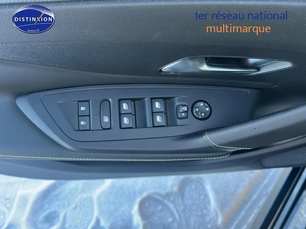 Gros plan sur la commande des vitres et rétroviseurs côté conducteur du Peugeot 408 Hybrid noir 2025.