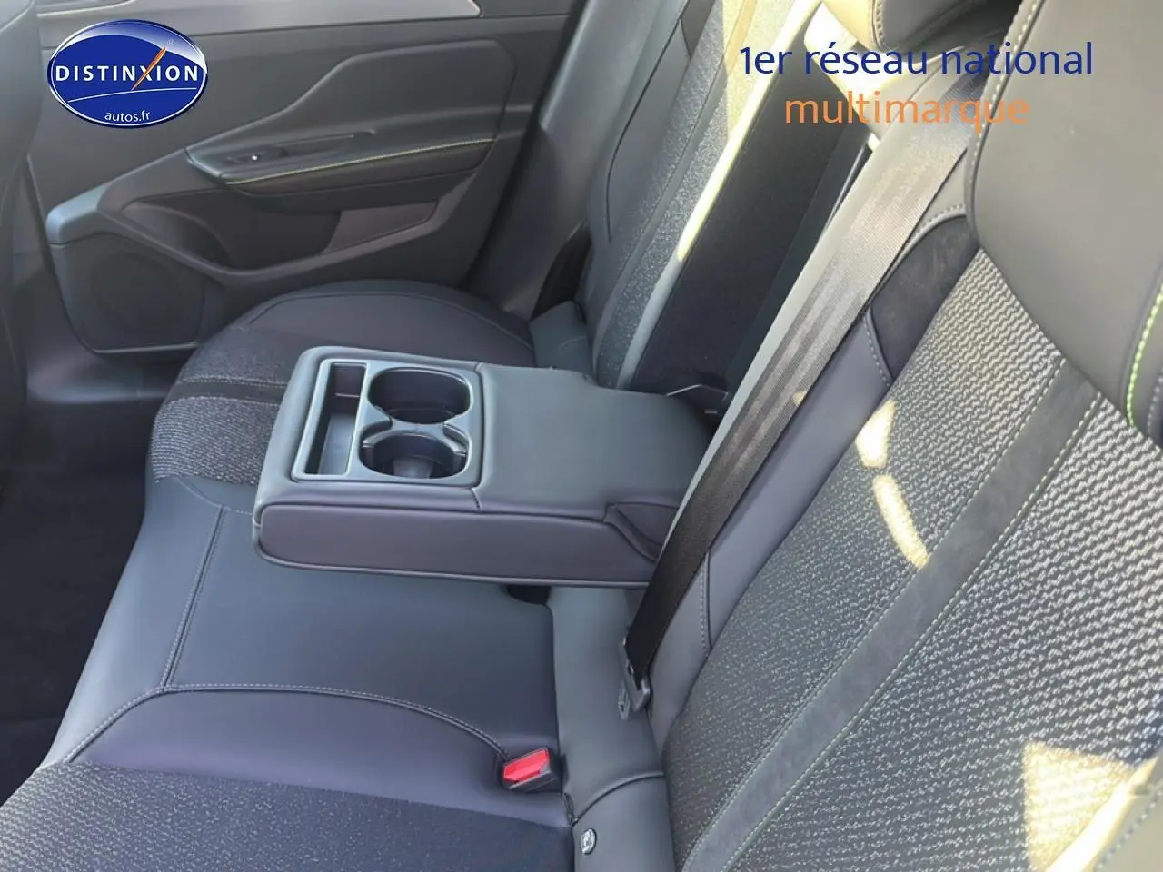 Vue intérieure de la banquette arrière côté droit de la Peugeot 408 Hybrid 145 GT e-dcs6 noire avec accoudoir central relevé.