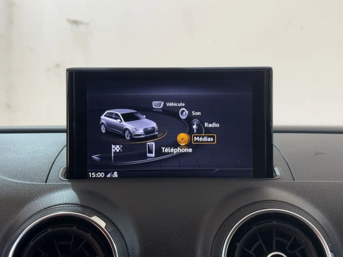 Écran multimédia central affichant le menu principal avec une Audi A3 grise en vue 3/4 avant.