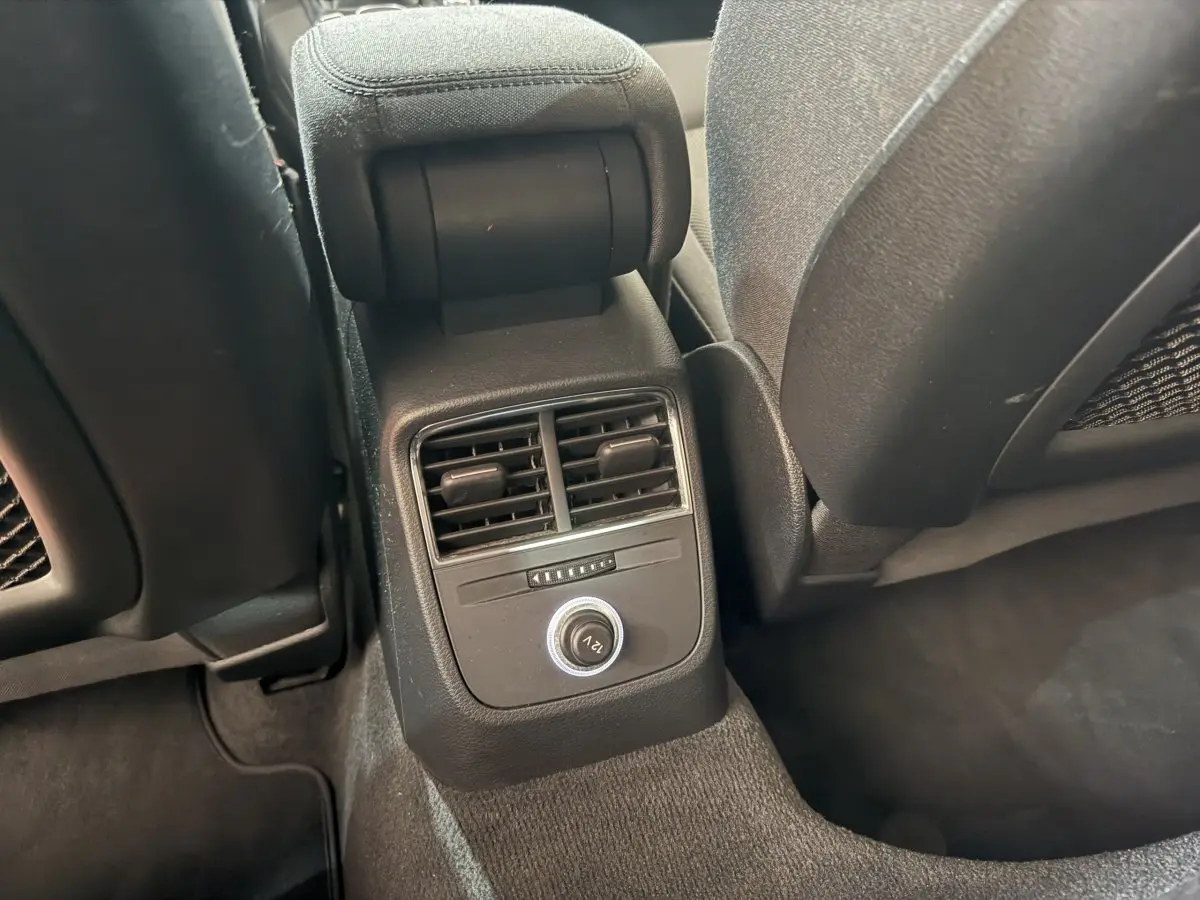 Vue rapprochée de la console arrière noire avec bouches d’aération et prise 12V de l’Audi A3 Business Line 2018.