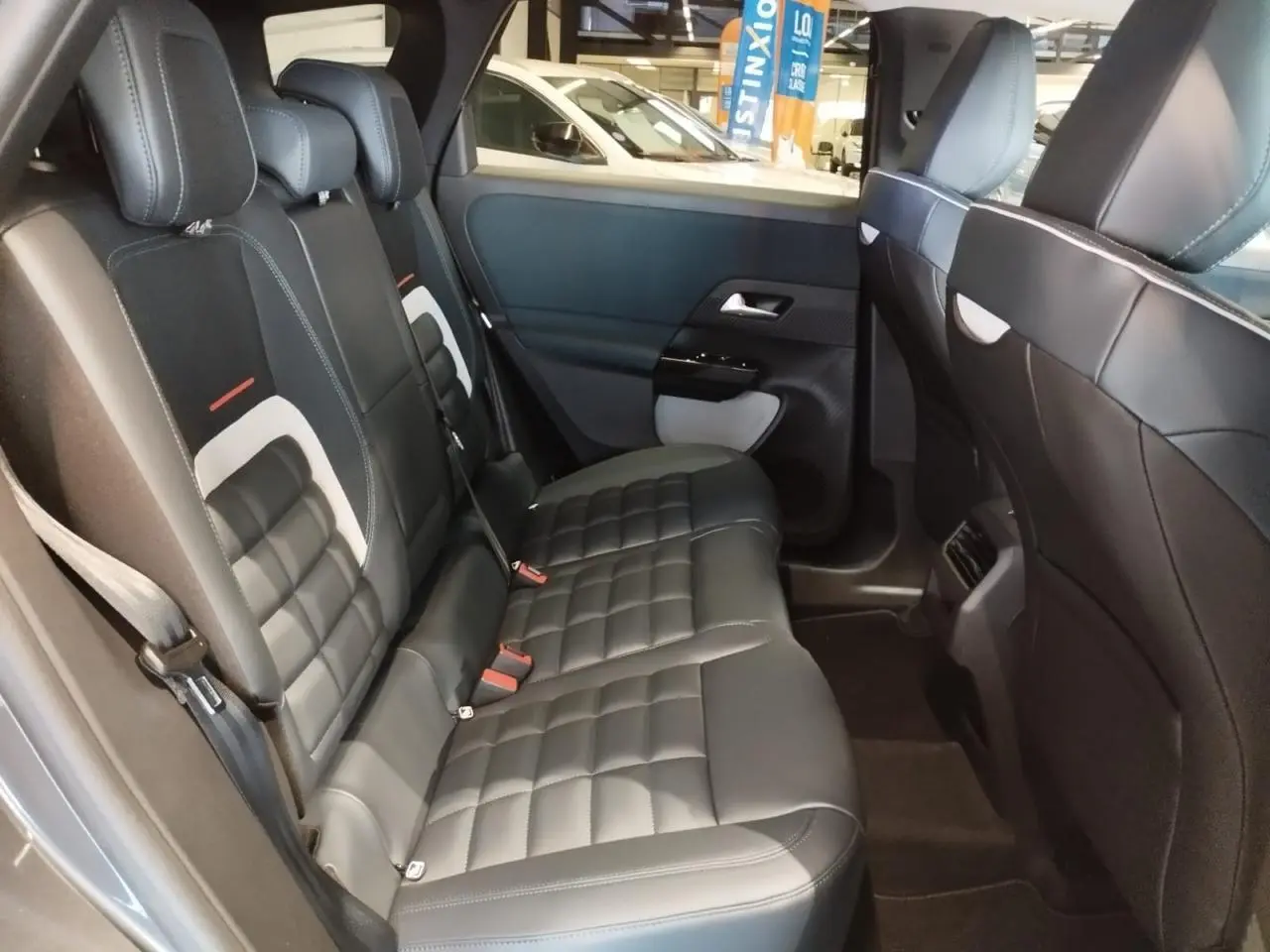 Vue intérieure des sièges arrière en cuir noir avec surpiqûres blanches du Citroën C5 Aircross gris platine 2026.