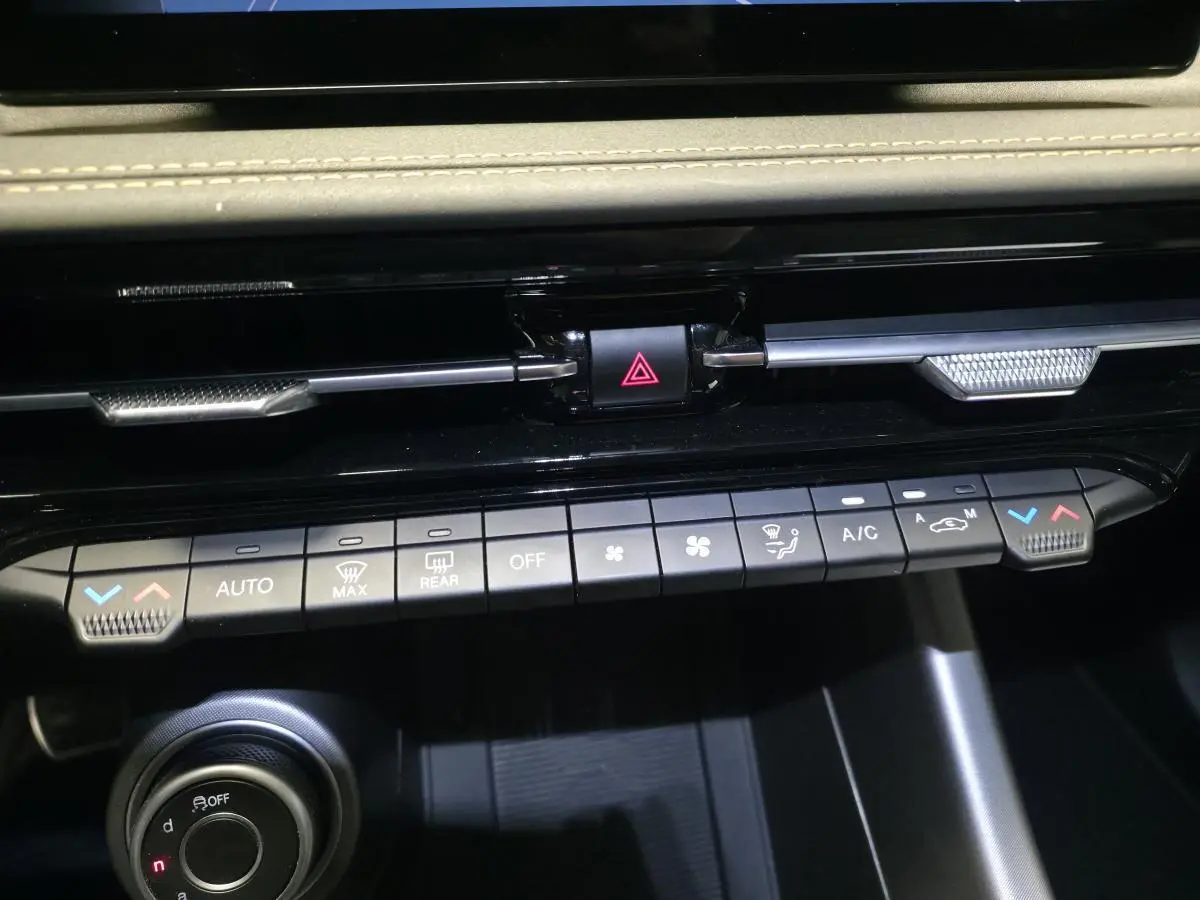 Vue rapprochée de la console centrale de l'Alfa Romeo Tonale 2025, avec commandes climatisation et bouton de danger.