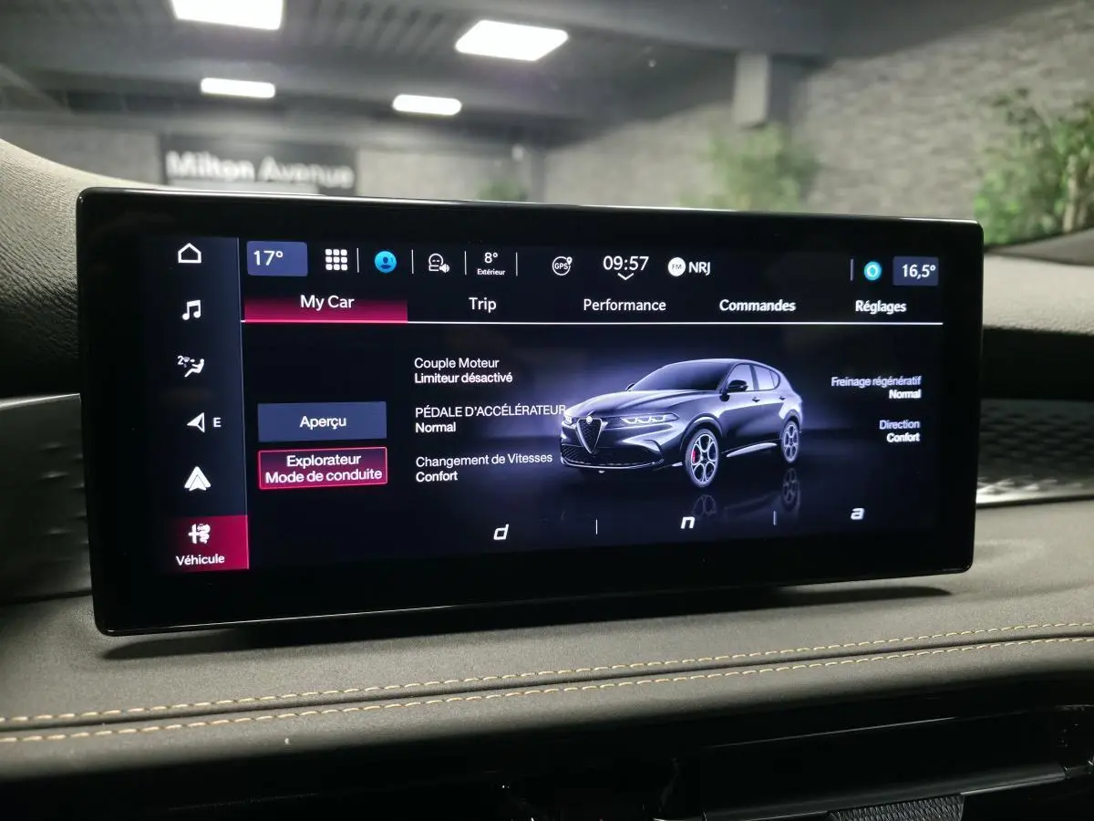 Écran tactile intérieur affichant une Alfa Romeo Tonale bleue en vue 3/4 avant avec paramètres de conduite.