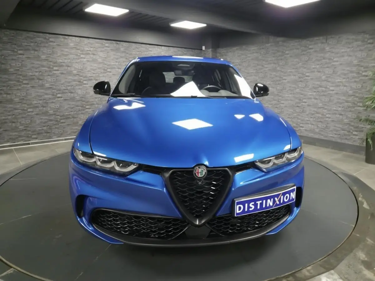 Vue frontale d'une Alfa Romeo Tonale 2025 bleu métallisé avec calandre noire et phares LED distinctifs.