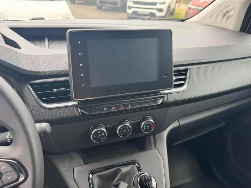 Tableau de bord et console centrale du Renault Kangoo Van blanc, vue de l'intérieur côté passager avec écran tactile et commandes clim.