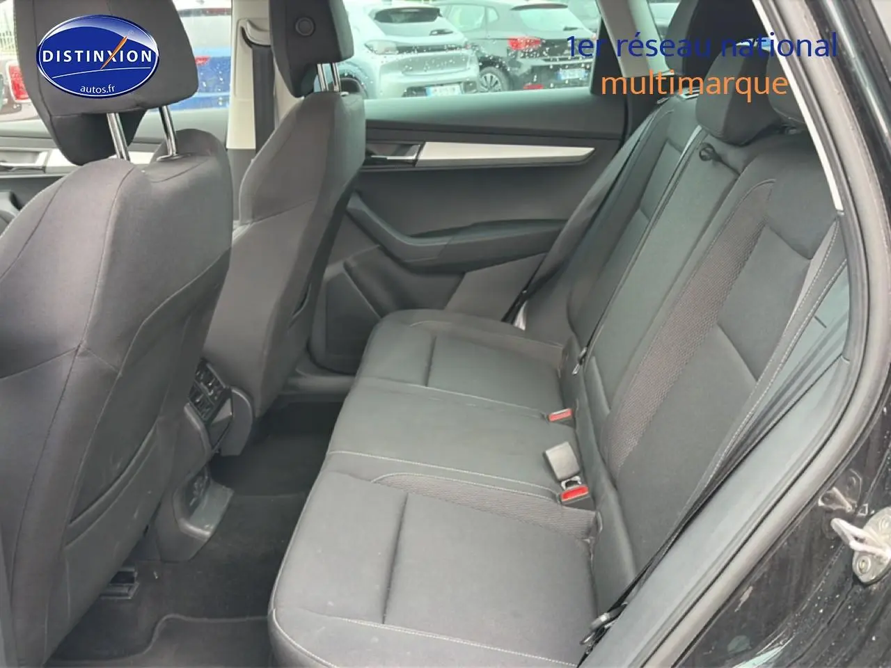 Vue intérieure côté droit montrant la banquette arrière noire du Skoda Karoq 2025, avec portes ouvertes.