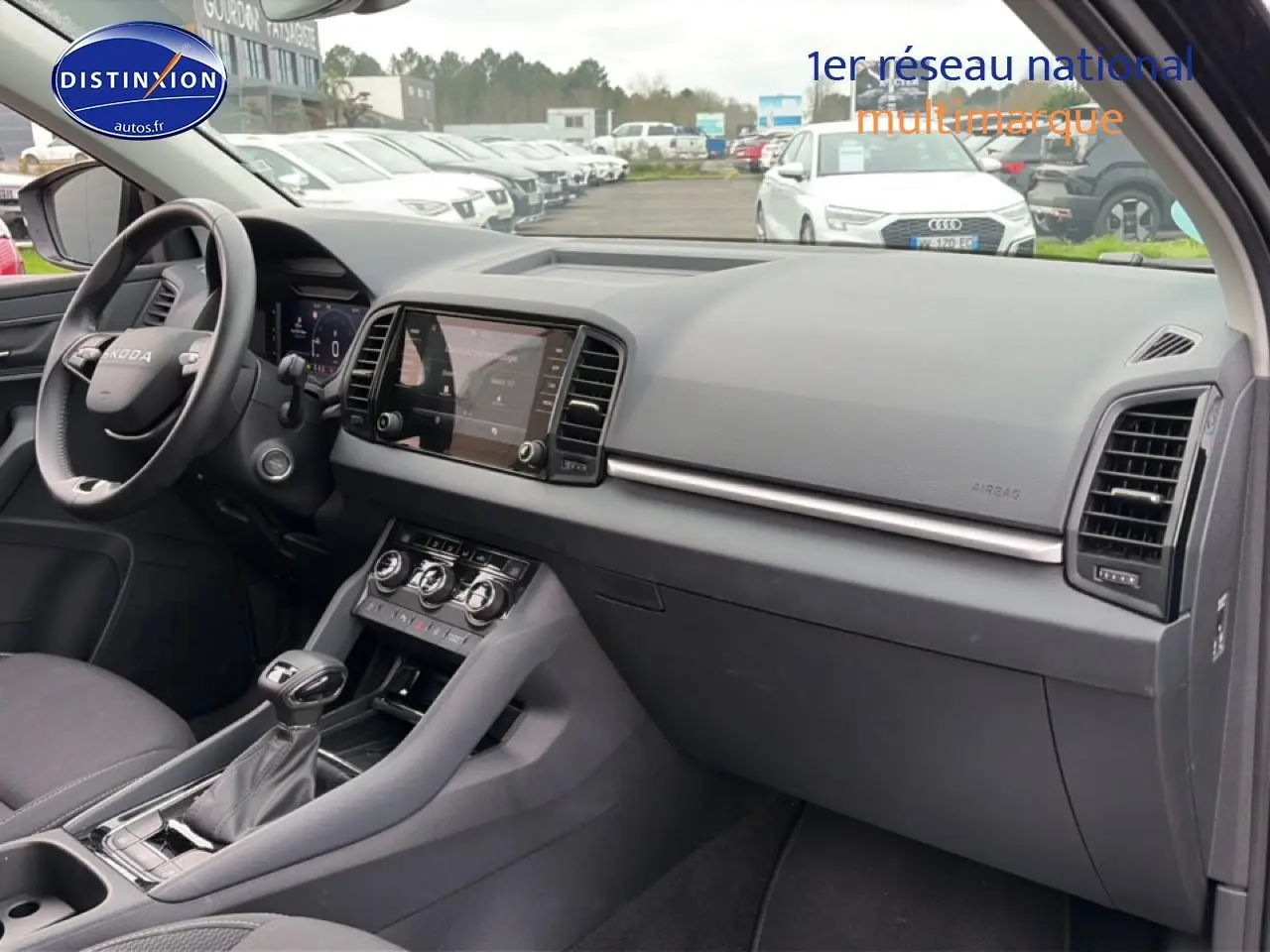 Vue intérieure côté passager du Skoda Karoq noir 2025, montrant tableau de bord et console centrale moderne.
