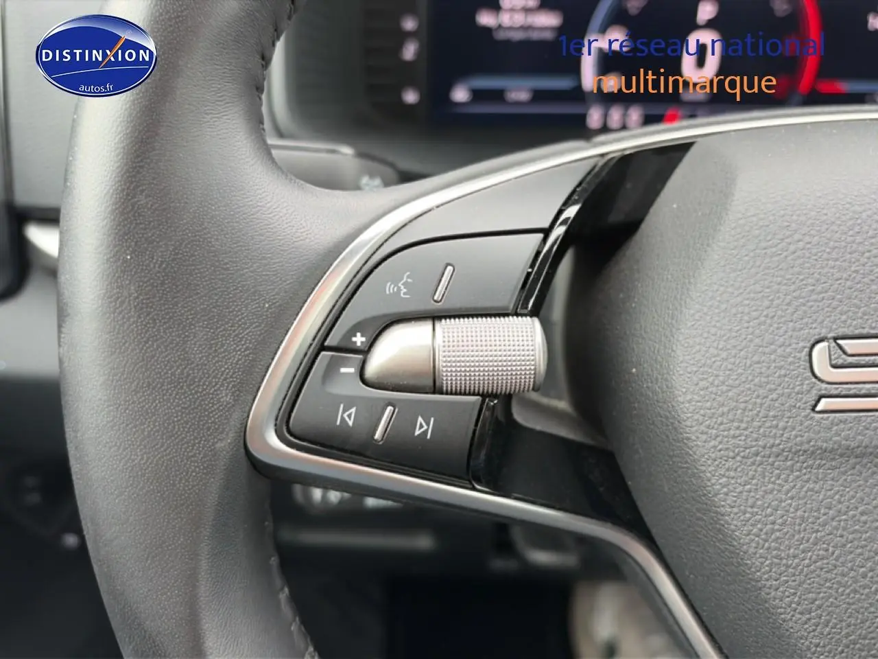 Gros plan sur les commandes audio au volant cuir noir du Skoda Karoq 2025, avec molette et boutons multifonctions.