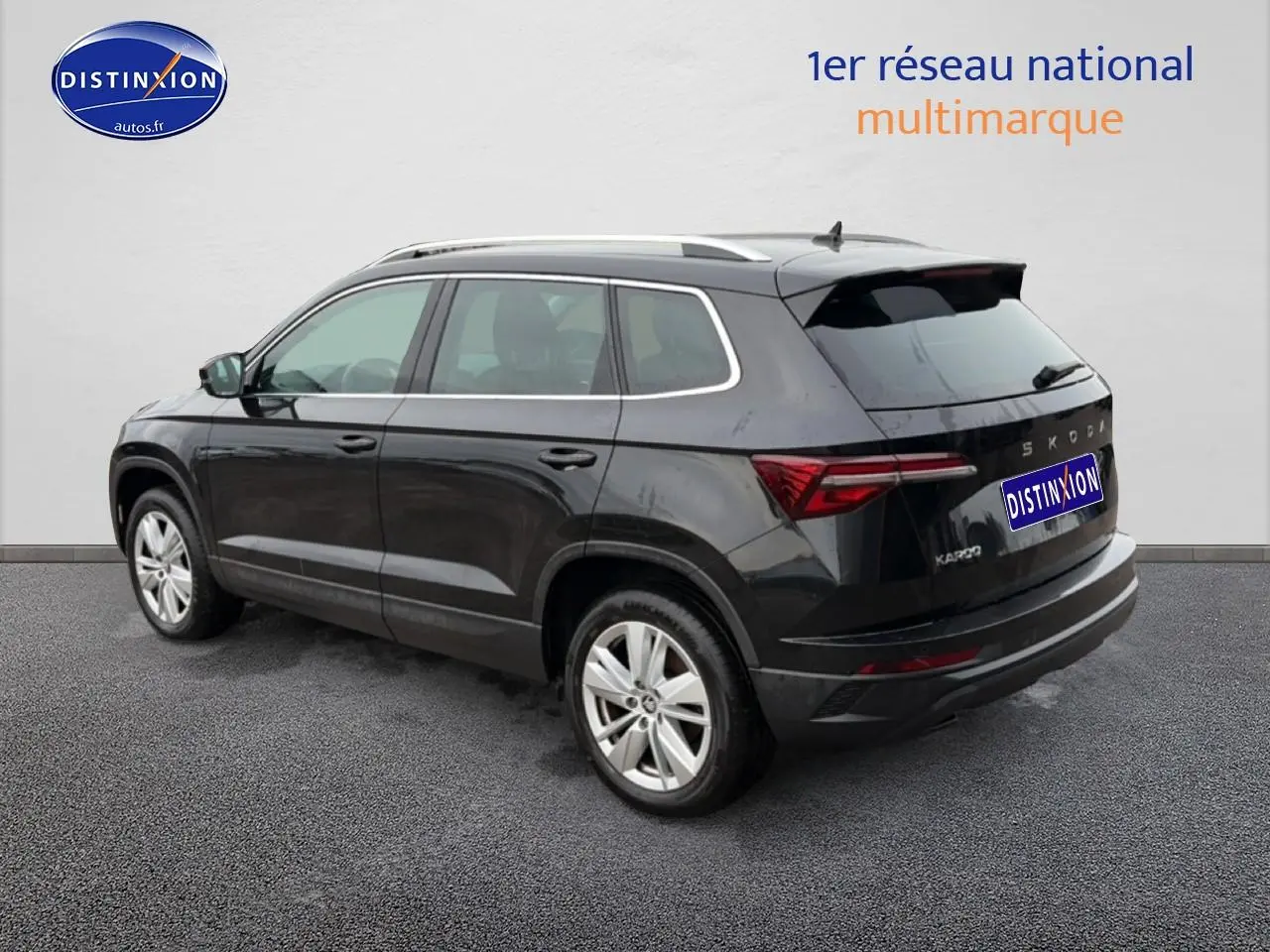 Vue 3/4 arrière droite d'un Skoda Karoq noir 2025 avec barres de toit et feux arrière LED distinctifs.