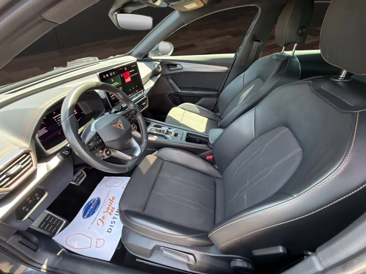 Vue intérieure côté conducteur du CUPRA Formentor 2025, sièges cuir noir et tableau de bord avec écran tactile central.
