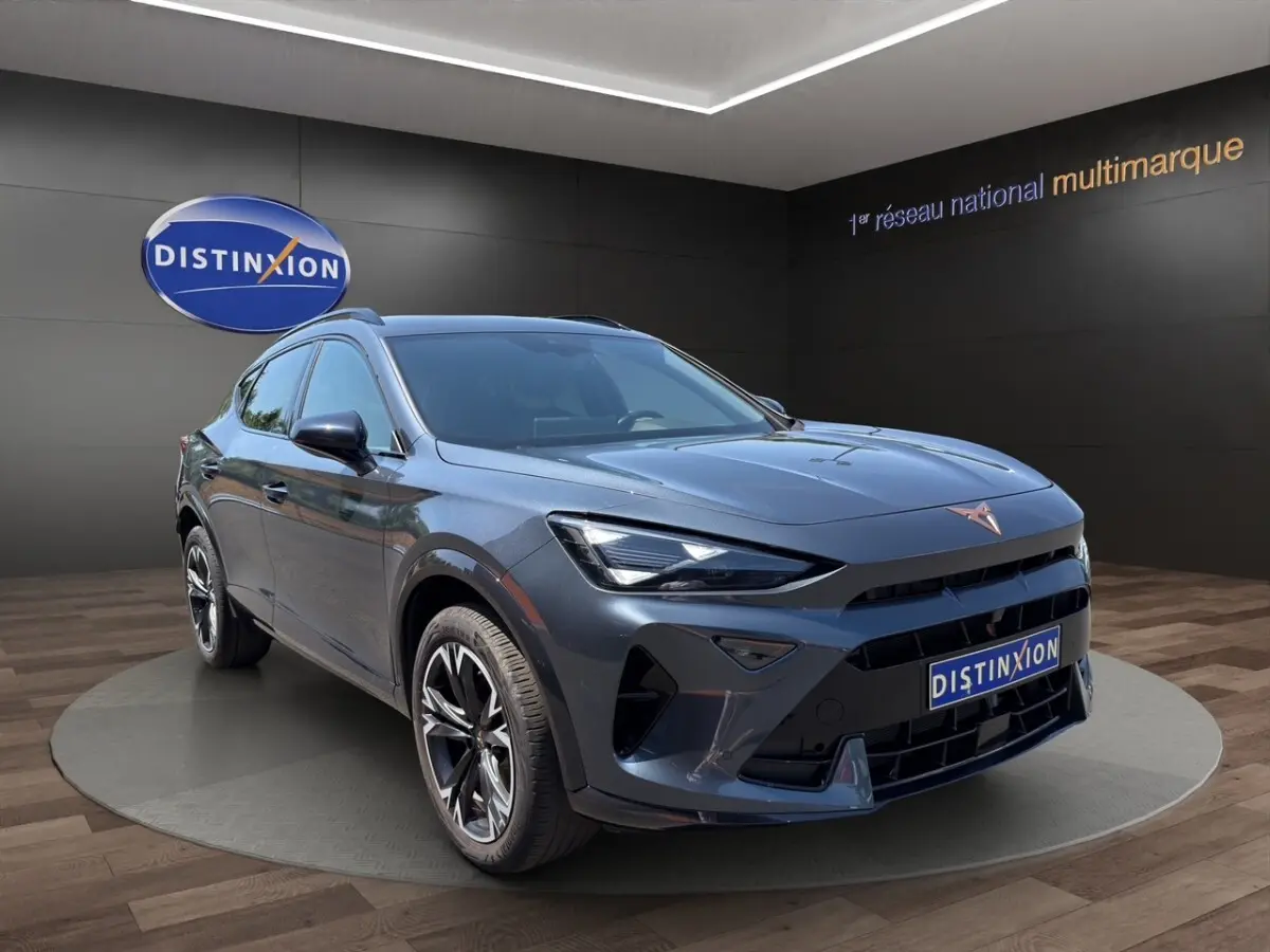Vue 3/4 avant droit d'une CUPRA Formentor gris foncé avec jantes noires et logo cuivre sur calandre.