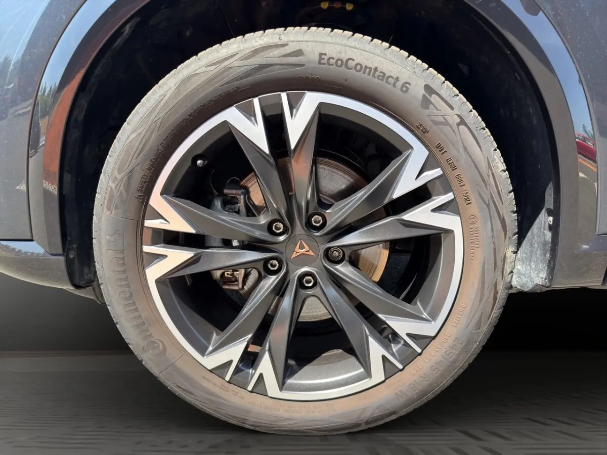 Gros plan sur la roue avant droite d’un CUPRA Formentor gris foncé avec jante alliage au design géométrique distinctif.