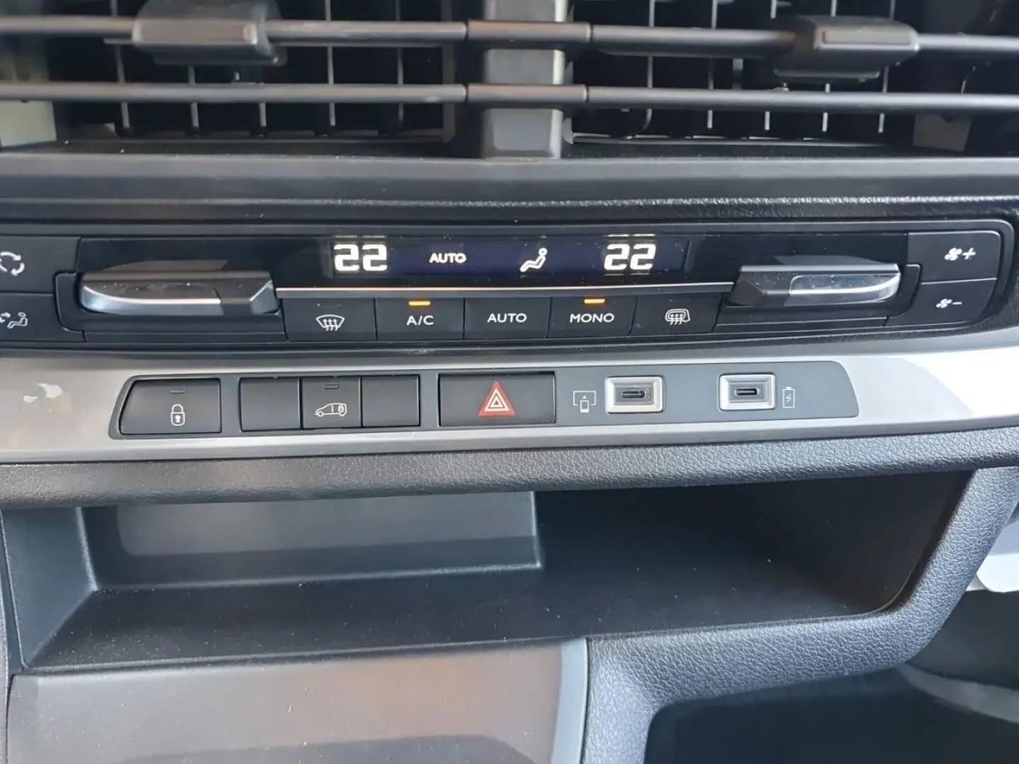 Détail du tableau de bord du Toyota Proace Fourgon blanc glacier, montrant les commandes de climatisation et ports USB.
