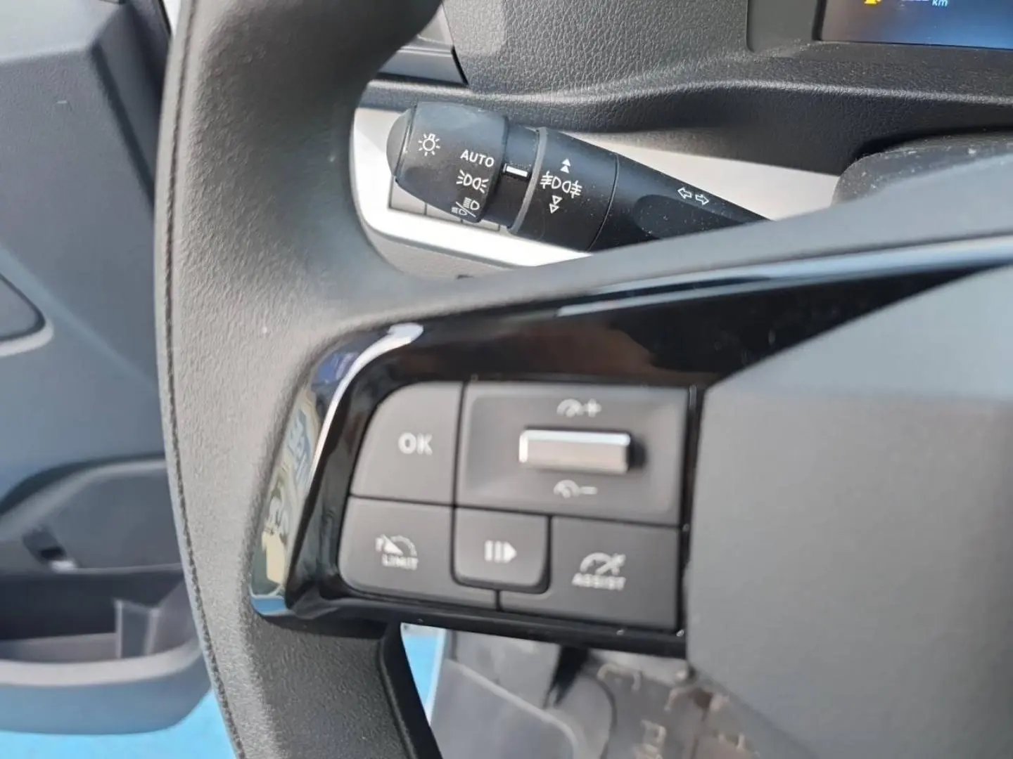 Gros plan sur les commandes au volant à gauche du Toyota Proace Fourgon blanc Glacier, avec levier de clignotants en arrière-plan.