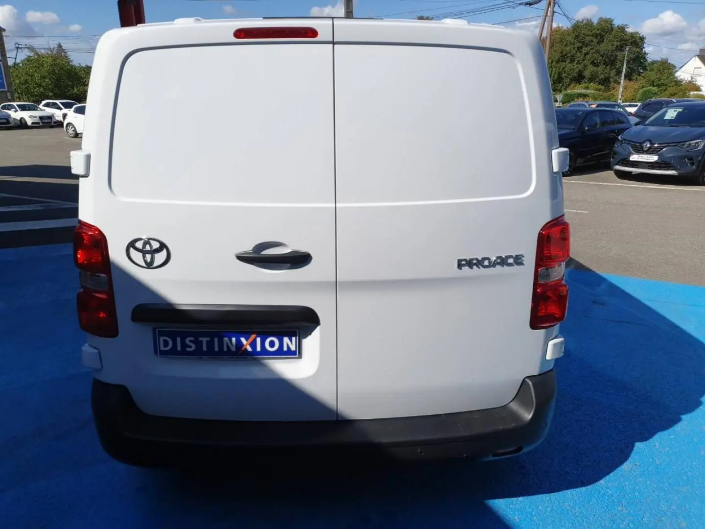 Vue arrière d'un Toyota Proace Fourgon blanc Glacier avec portes battantes et feux rouges visibles.