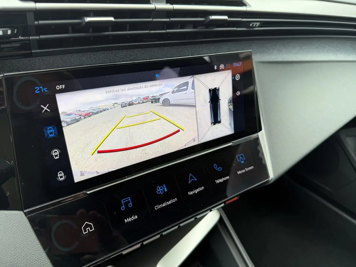 Écran tactile central de la Peugeot 308 SW rouge montrant la caméra de recul et l'affichage 360° intérieur.