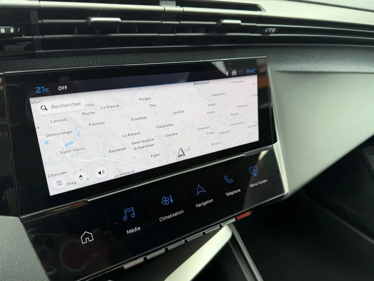 Vue rapprochée de l’écran tactile central du tableau de bord de la Peugeot 308 SW rouge, affichant la navigation.